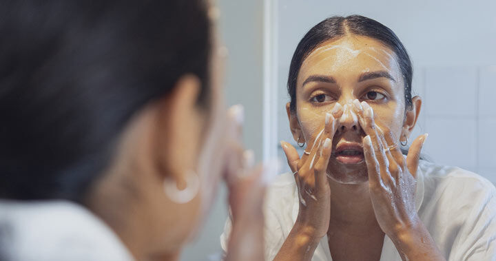 Kvinna som rengör sitt ansikte