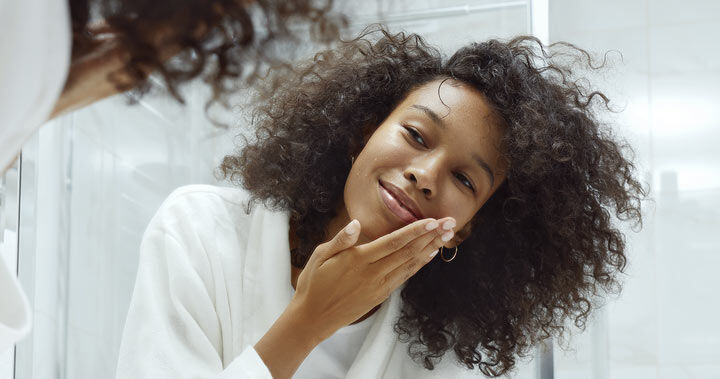 Kvinna sköljer sitt ansikte